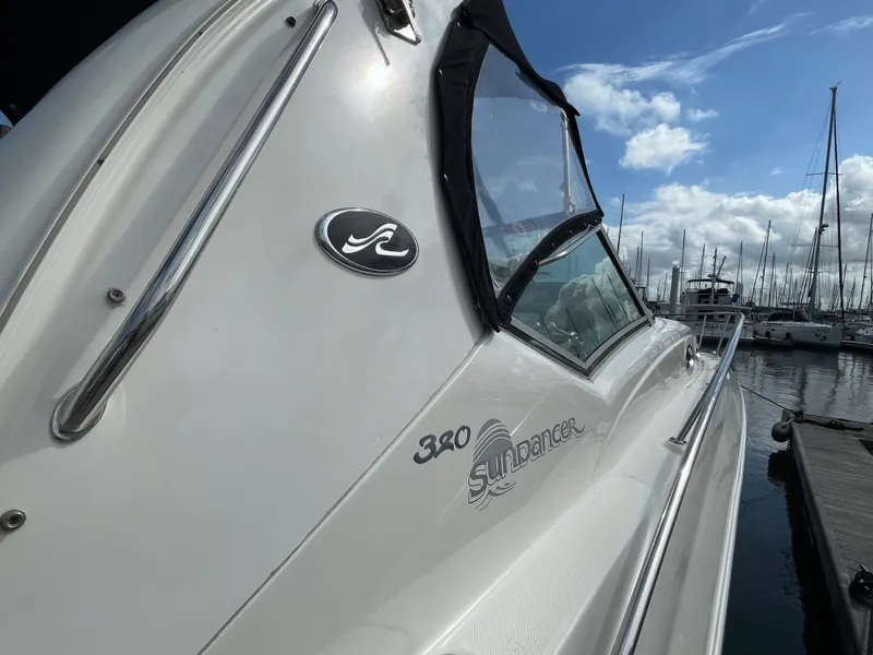 Slide: The Image of 2006 Sea Ray 320 Sundancer docked at a marina under a blue sky. - 7