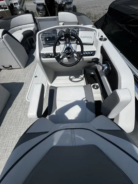 Slide: The Image of 2024 Avalon LSZ VRB boat cockpit with modern steering wheel and Garmin navigation system. - 2