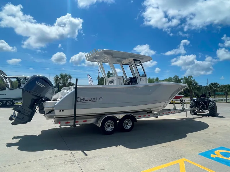 Slide: The Image of 2023 Robalo R270 boat on a trailer under a sunny sky. - 1