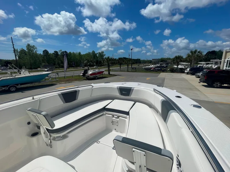 Slide: The Image of 2023 Robalo R270 boat with spacious seating and modern design under a clear blue sky. - 18