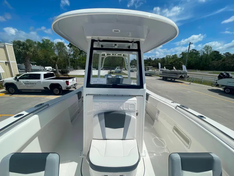 Slide: The Image of 2023 Robalo R270 boat with center console and seating, docked in a marina. - 20