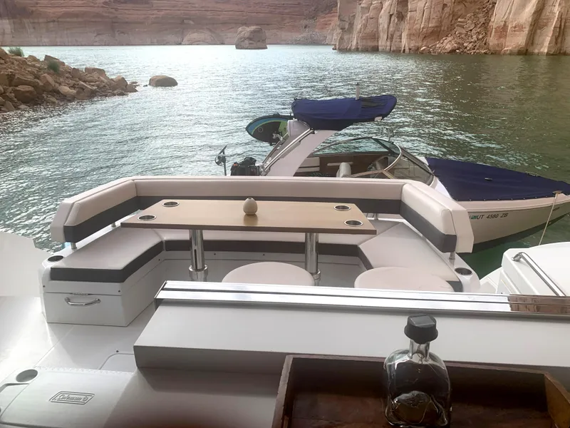 Slide: The Image of 2018 Cruisers Yachts CANTIUS 54 on serene water with scenic rocky backdrop. - 8