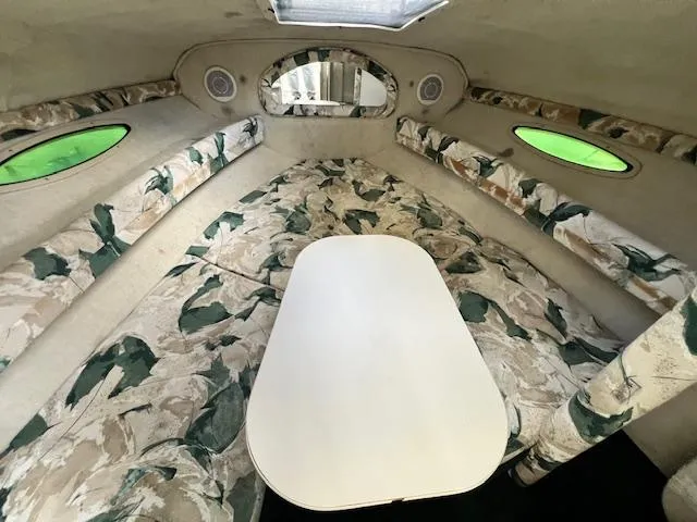 Slide: The Image of Interior cabin of a 1999 Sea Ray 215 Express Cruiser with floral upholstery and a central table. - 11