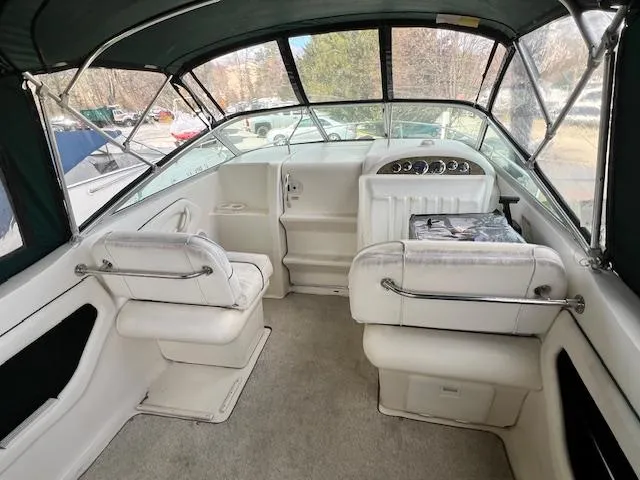 Slide: The Image of 1999 Sea Ray 215 Express Cruiser interior with white seating and dashboard. - 5