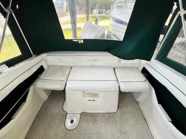 Slide: The Image of Interior of a 1999 Sea Ray 215 Express Cruiser with white seating and green canopy. - 7