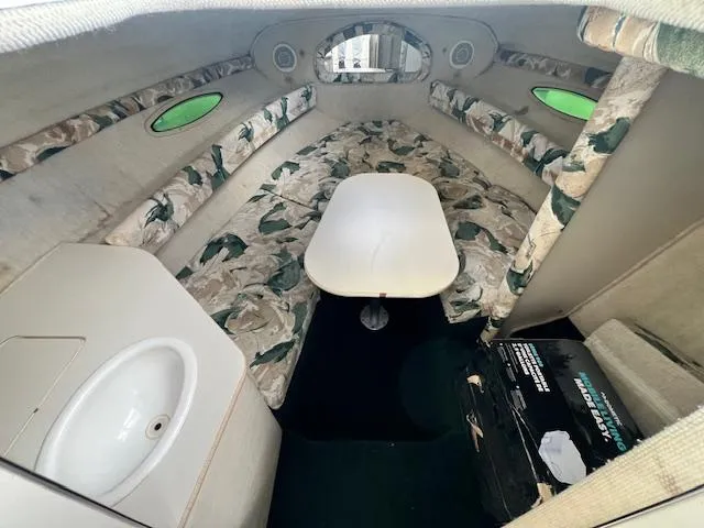 Slide: The Image of 1999 Sea Ray 215 Express Cruiser cabin interior with table and sink. - 9
