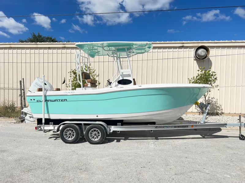 Slide: The Image of 2024 Clearwater 2200 boat on a trailer, light blue hull, parked outdoors. - 19
