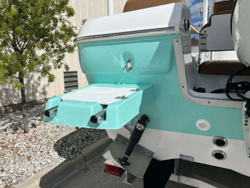 Slide: The Image of 2024 Clearwater 2200 boat with teal and white exterior, rear view showing swim platform. - 21