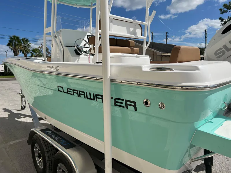 Slide: The Image of 2024 Clearwater 2200 boat on trailer, turquoise hull, outdoor setting. - 22