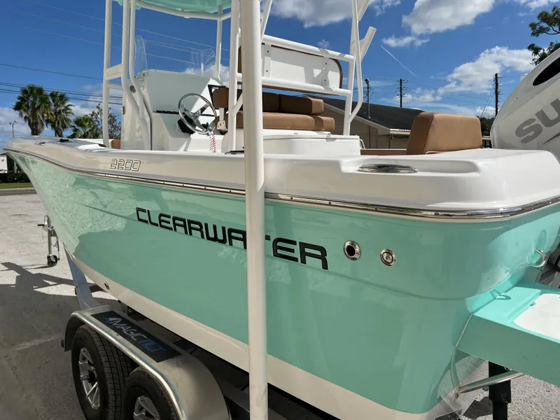Slide: The Image of 2024 Clearwater 2200 boat on trailer, turquoise hull, outdoor setting. - 23