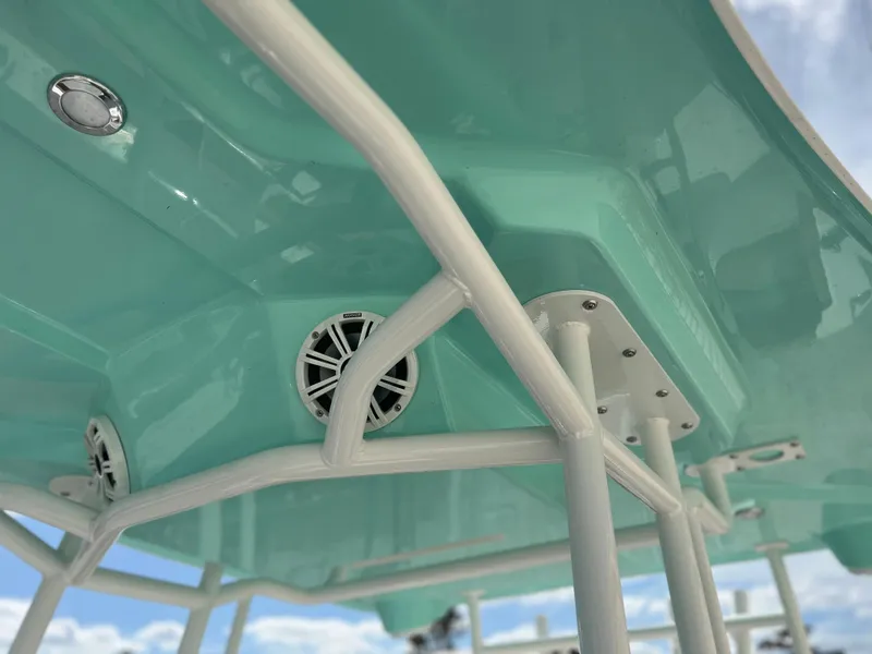 Slide: The Image of 2024 Clearwater 2200 boat with teal canopy and white frame. - 34