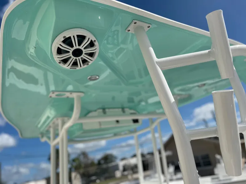 Slide: The Image of 2024 Clearwater 2200 boat with teal canopy and speaker system. - 35