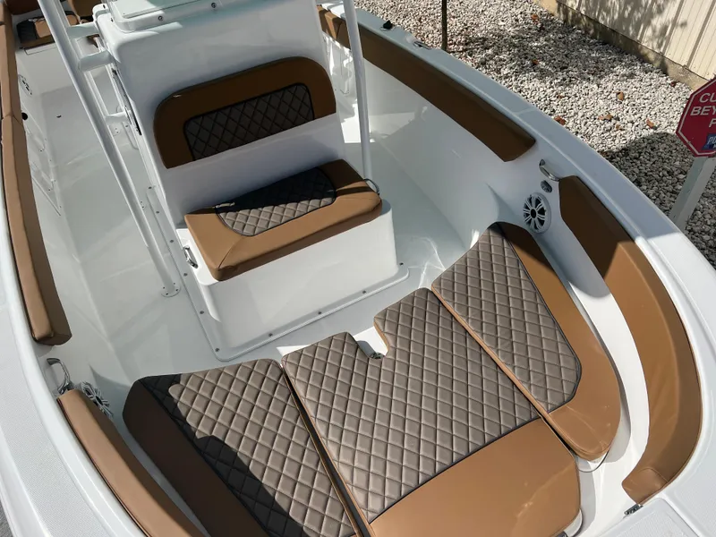 Slide: The Image of 2024 Clearwater 2200 boat interior with brown and black diamond-stitched seating. - 37