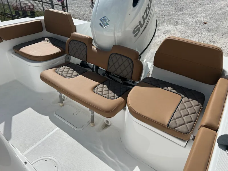 Slide: The Image of 2024 Clearwater 2200 boat with brown cushioned seating and Suzuki outboard motor. - 49