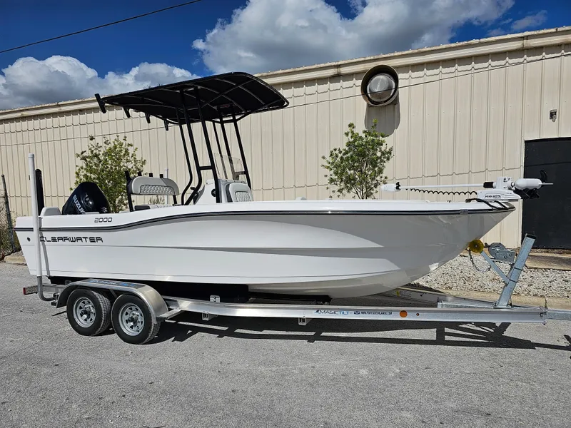 Slide: The Image of Clearwater 2000 2023 model boat on a trailer, parked outdoors under a blue sky. - 5