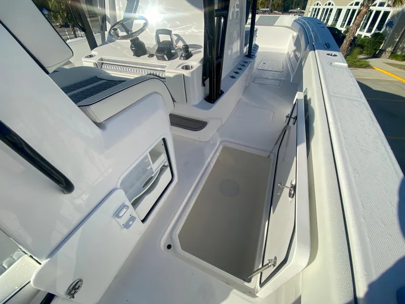 Slide: The Image of 2024 Invincible 35 Catamaran interior with open storage compartment and helm station. - 16