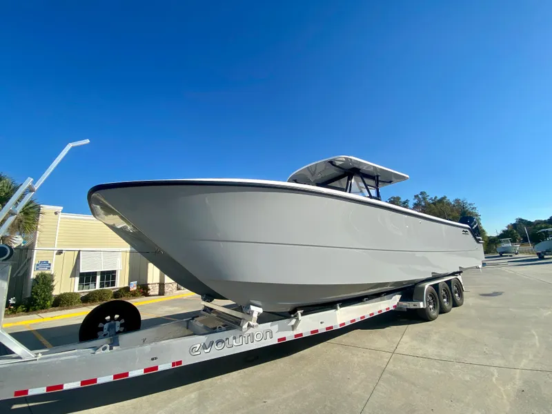 Slide: The Image of 2024 Invincible 35 Catamaran on trailer under clear blue sky. - 1