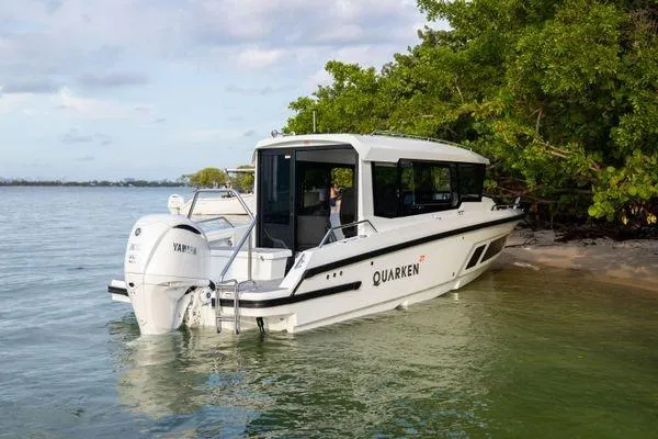 Slide: The Image of 2024 Quarken 27 Cabin boat docked near a lush shoreline. - 11