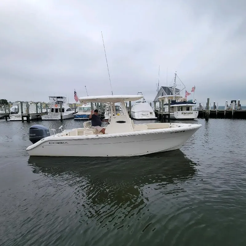 Slide: The Image of 2019 Cobia 240 CC boat docked in a marina. - 0