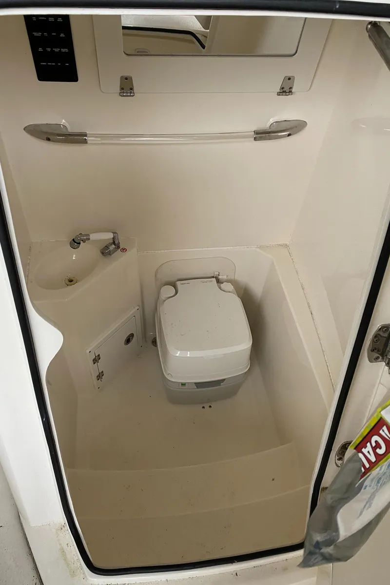 Slide: The Image of 2019 Cobia 240 CC boat interior bathroom with toilet and sink. - 19