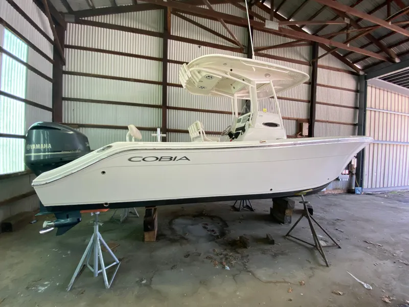 Slide: The Image of 2019 Cobia 240 CC boat in a storage shed with Yamaha outboard motor. - 26