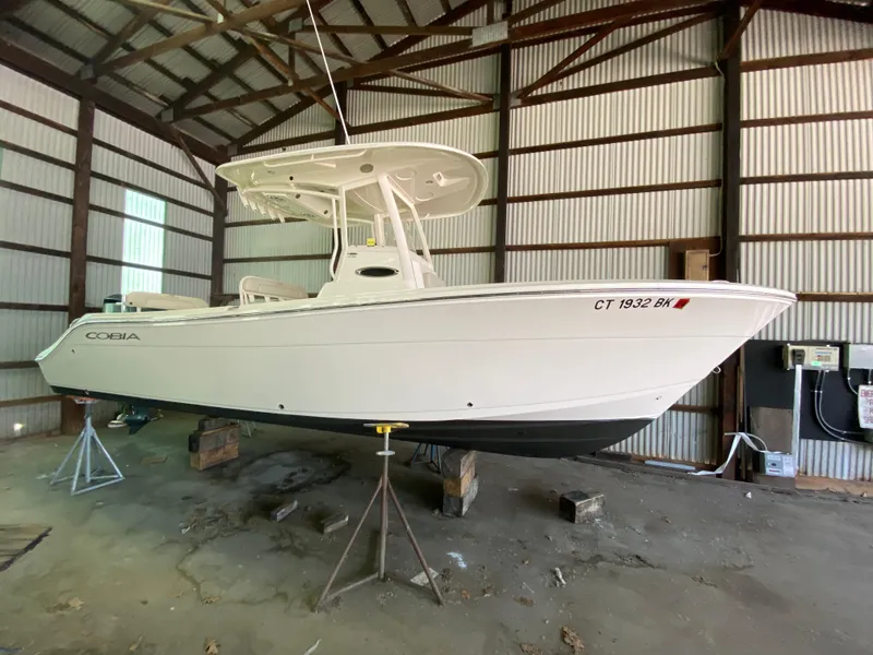 Slide: The Image of 2019 Cobia 240 CC boat in storage shed. - 27