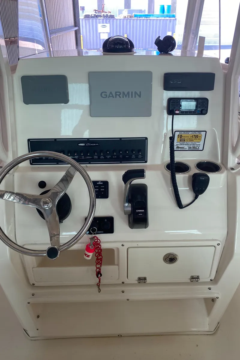 Slide: The Image of 2019 Cobia 240 CC boat console with Garmin navigation system and controls. - 8
