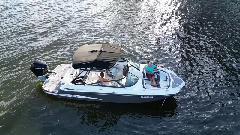 Slide: The Image of 2021 Monterey M-45 boat cruising on water with passengers under a canopy. - 13