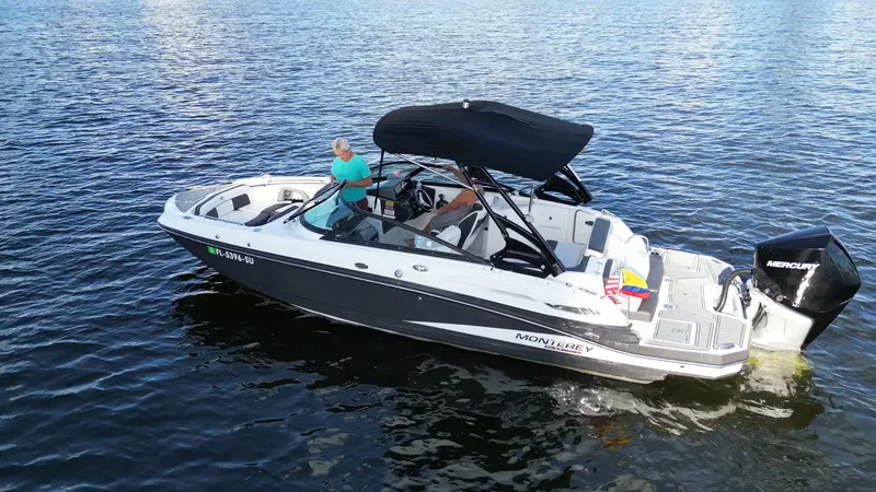 Slide: The Image of 2021 Monterey M-45 boat with black canopy cruising on calm water. - 2