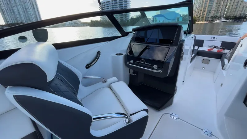 Slide: The Image of 2021 Monterey M-45 boat interior with sleek seating and modern dashboard, docked by waterfront. - 32