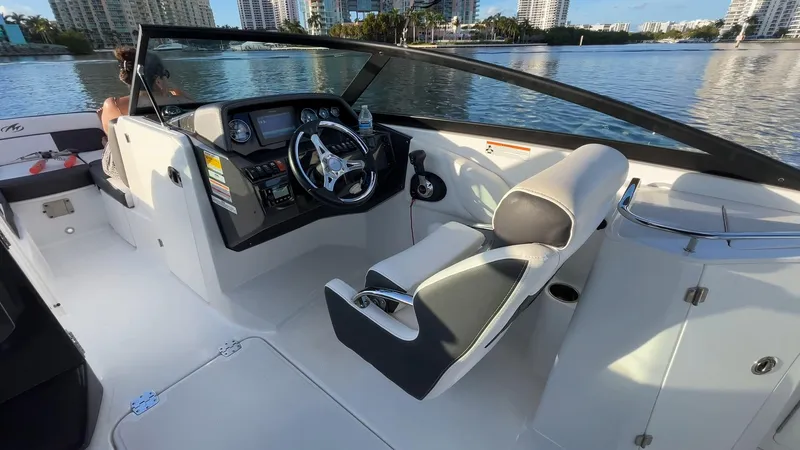 Slide: The Image of 2021 Monterey M-45 boat interior with steering wheel and seating, docked by waterfront buildings. - 33