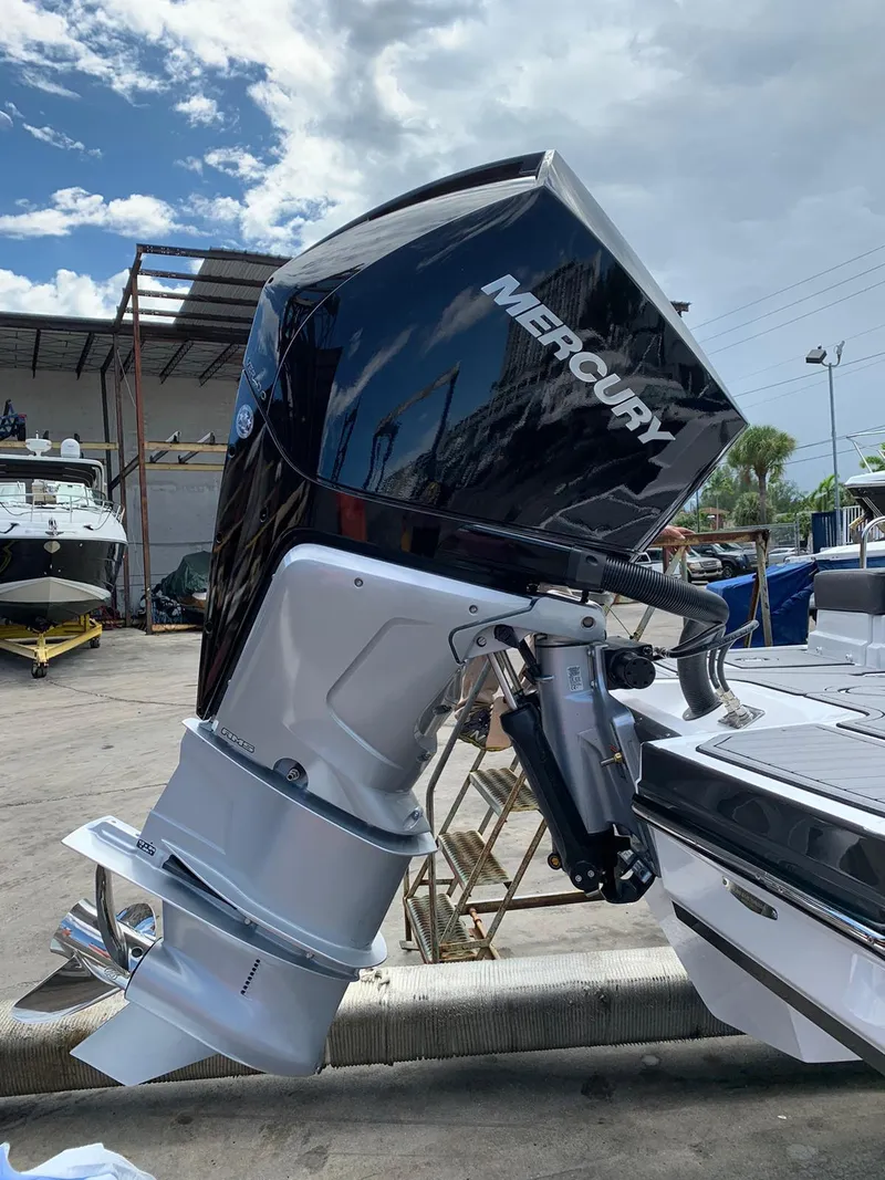 Slide: The Image of Mercury outboard motor on a 2021 Monterey M-45 boat, docked under a partly cloudy sky. - 47