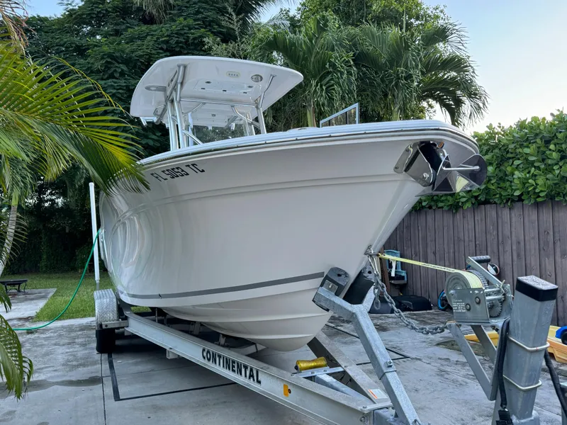 Slide: The Image of 2022 Sea Fox 248 Commander boat on a Continental trailer, surrounded by lush greenery. - 5