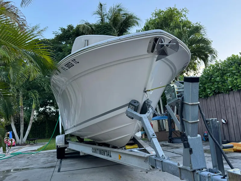 Slide: The Image of 2022 Sea Fox 248 Commander boat on a trailer, surrounded by tropical foliage. - 6