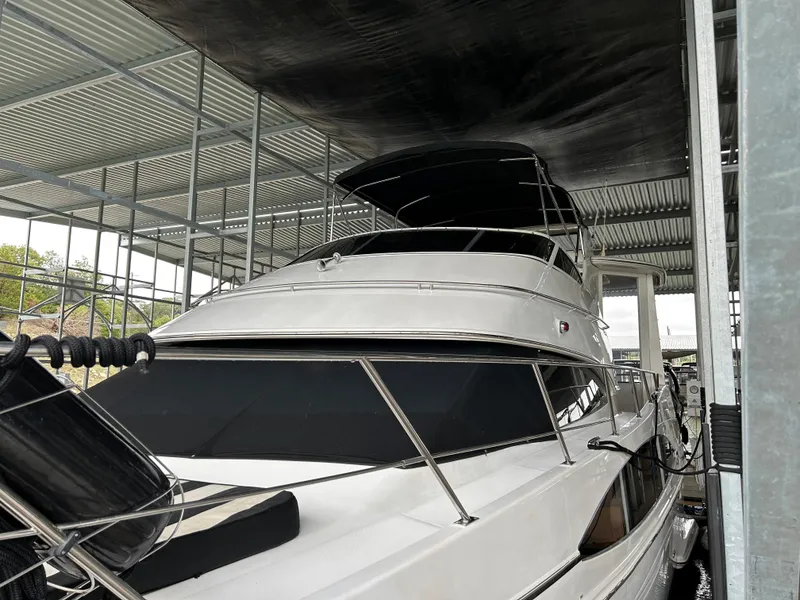 Slide: The Image of Carver 396 yacht from 2000 docked under a metal canopy. - 13