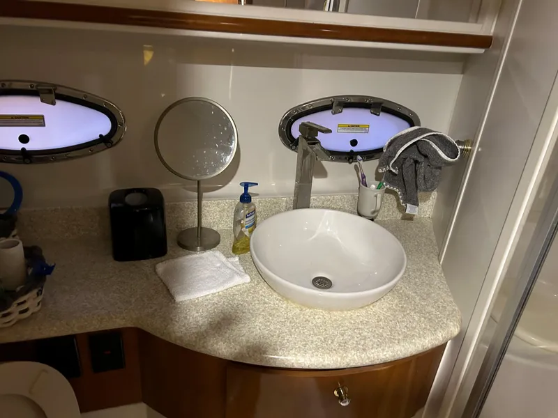 Slide: The Image of Bathroom sink area in a 2000 Carver 396 yacht with porthole windows. - 18