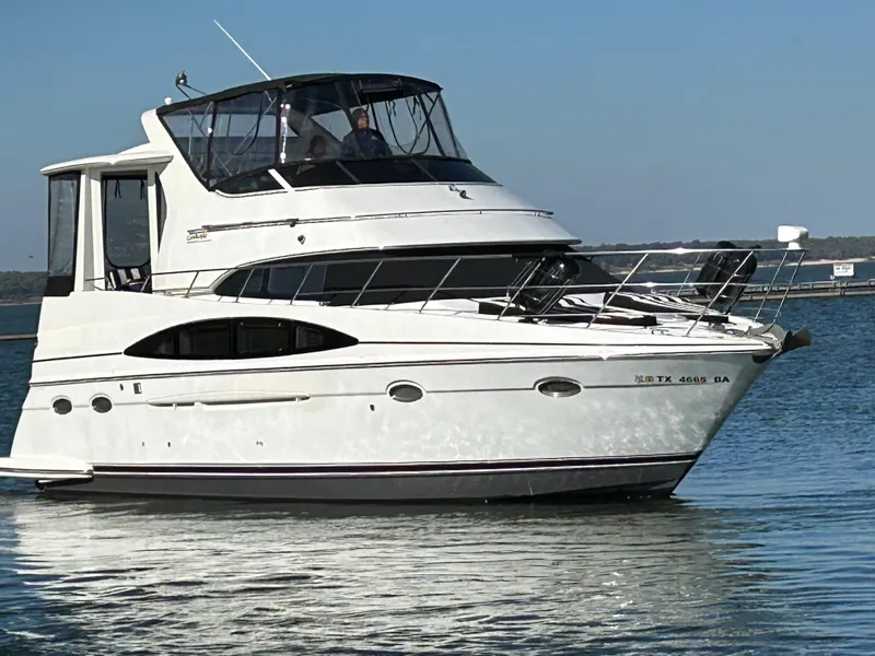 Slide: The Image of 2000 Carver 396 yacht on calm water, featuring sleek design and spacious upper deck. - 2