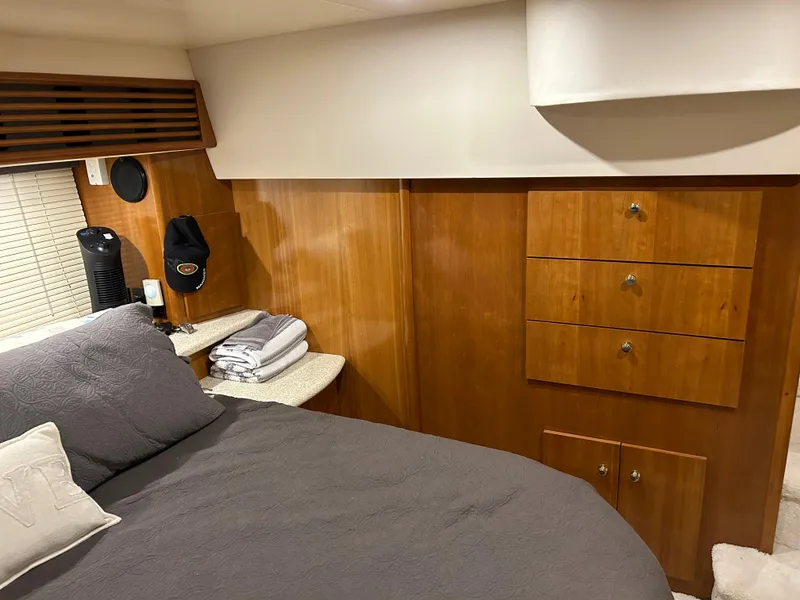 Slide: The Image of Cozy bedroom interior of 2000 Carver 396 yacht with wooden cabinets and bed. - 20