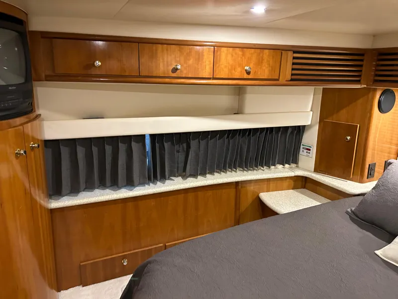 Slide: The Image of 2000 Carver 396 yacht interior with wood cabinetry and cozy sleeping area. - 21