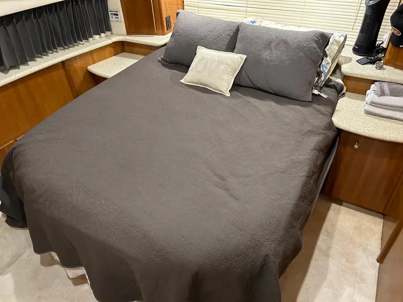 Slide: The Image of Cozy bedroom in 2000 Carver 396 yacht with brown bedding and wooden cabinetry. - 22