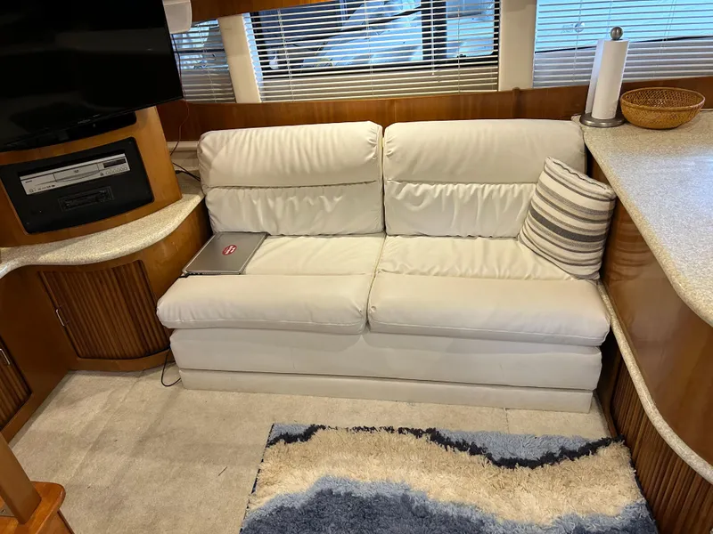 Slide: The Image of Interior of a 2000 Carver 396 yacht with a white sofa and striped pillow. - 26