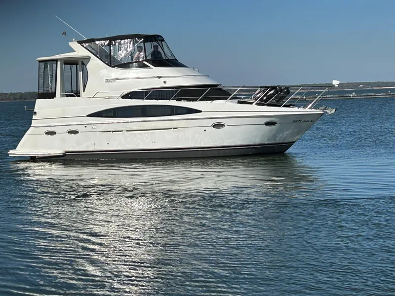 Slide: The Image of 2000 Carver 396 yacht on calm water under clear blue sky. - 3