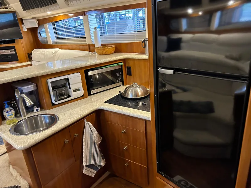 Slide: The Image of Compact kitchen in a 2000 Carver 396 yacht with modern appliances and wood cabinetry. - 30