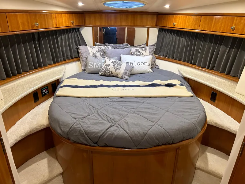 Slide: The Image of Luxurious cabin interior of 2000 Carver 396 yacht with cozy bedding and elegant wood finish. - 34