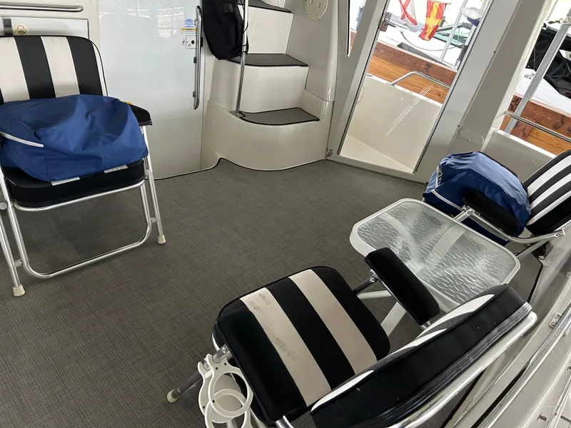 Slide: The Image of Interior of 2000 Carver 396 yacht with striped chairs and glass table. - 39