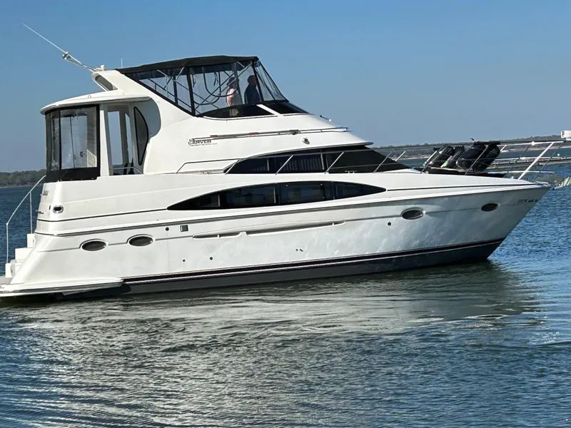 Slide: The Image of 2000 Carver 396 yacht cruising on calm waters under clear blue skies. - 4