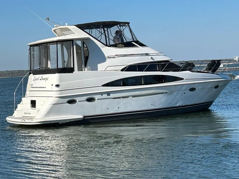 Slide: The Image of 2000 Carver 396 yacht cruising on calm waters under a clear blue sky. - 6