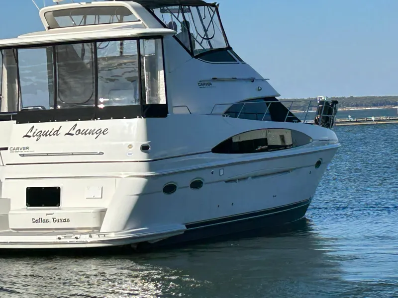 Slide: The Image of Carver 396 yacht named "Liquid Lounge" docked in calm waters, 2000 model. - 7
