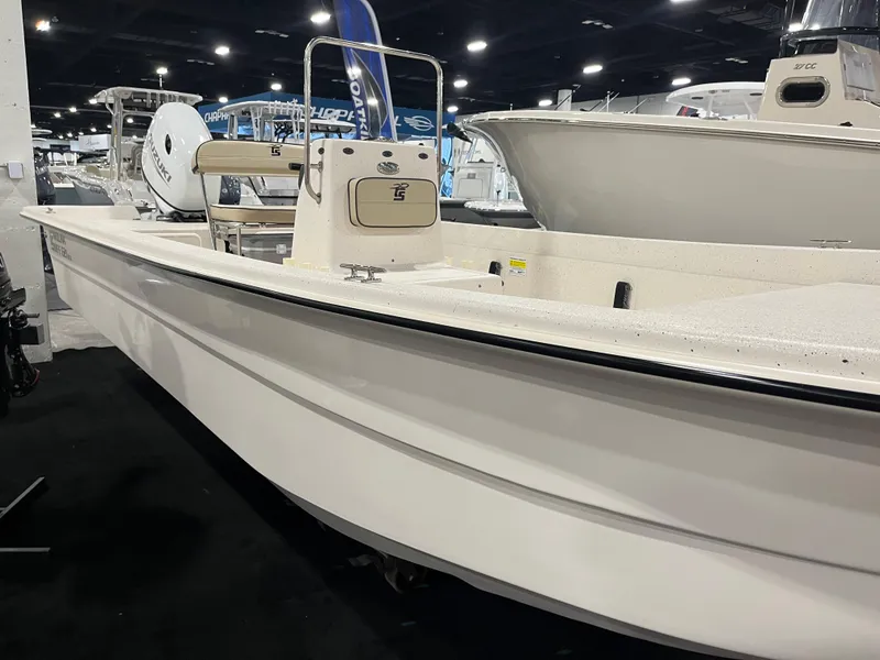Slide: The Image of 2024 Carolina Skiff e21 DLX boat on display at an indoor boat show. - 0