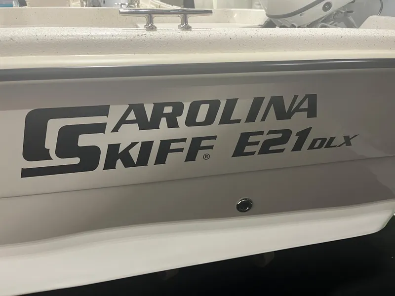 Slide: The Image of 2024 Carolina Skiff e21 DLX boat model logo on the side. - 1